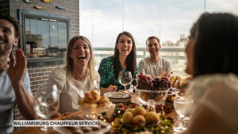 Happy multi-generational family smiling and talking around a dinner table, enjoying a relaxed reunion together in a warm, inviting atmosphere.