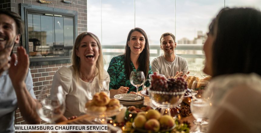 Happy multi-generational family smiling and talking around a dinner table, enjoying a relaxed reunion together in a warm, inviting atmosphere.